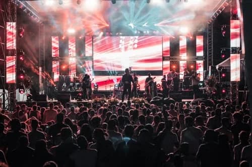 Generic stock atmosphere: concert crowd watching a brightly lit live stage, not this event or venue