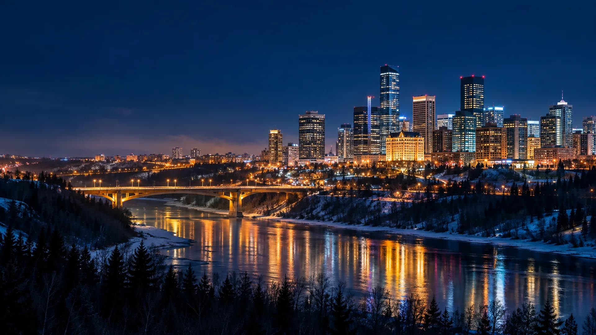 Edmonton skyline glowing above the North Saskatchewan River at night